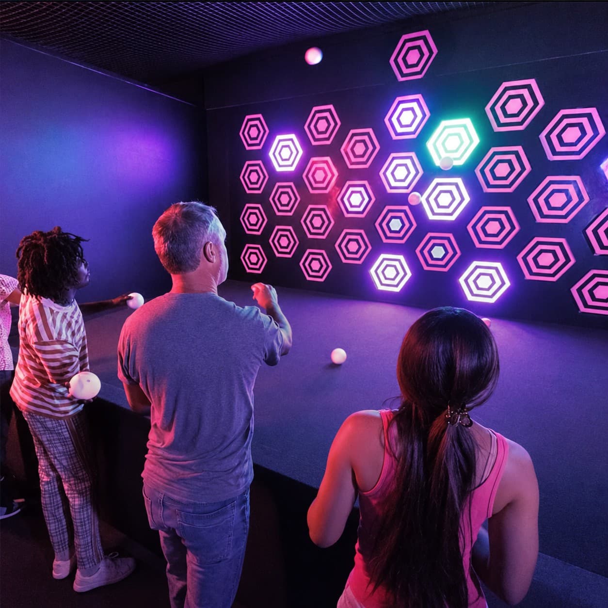 Joueurs visant le mur de cibles hexagonales interactives ARENA